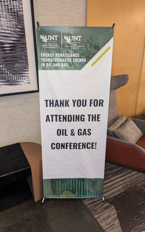 Banner stand thanks attendees of an oil and gas conference, displaying UNT logos and information about energy accounting and sustainability.